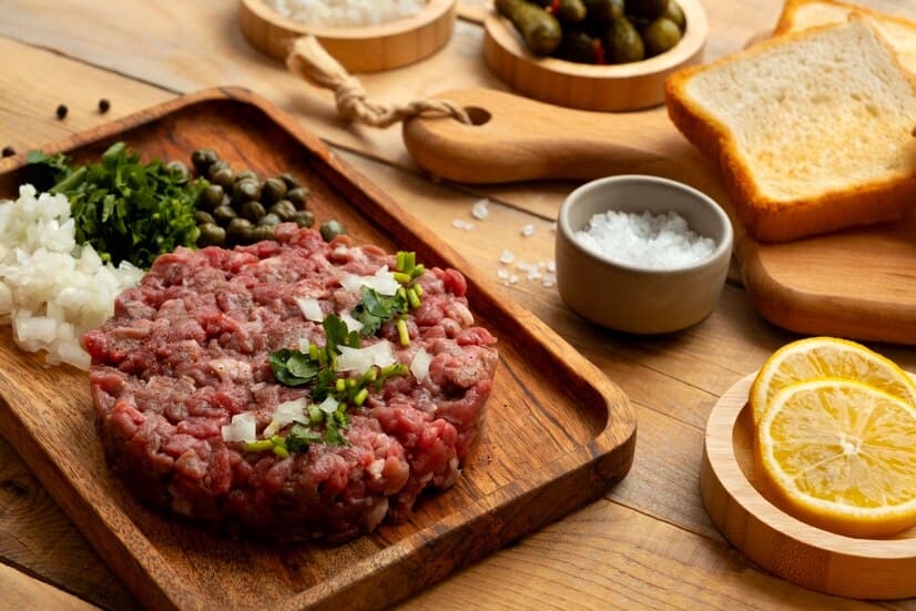 Beef Steak Tartar and Orange Slices on the Desk